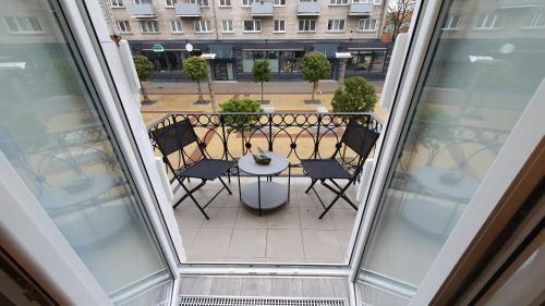 a balcony with a table and chairs on a patio at Мazvydo Avenue Studio Кlaipeda City Centre in Klaipėda