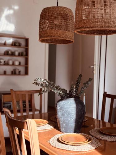 a dining room table with a vase with a plant at Bragorski Apartment in Makedonski Brod