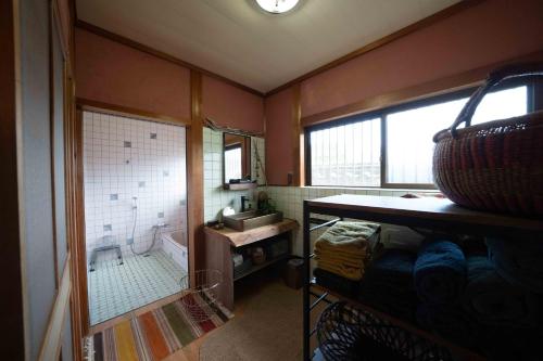 a small bathroom with a tub and a sink at 錆と煤 sabitosusu INN-prema- in Aki