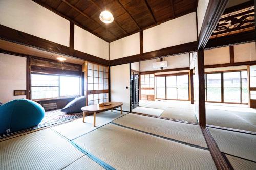 a large room with a table and some windows at 錆と煤 sabitosusu INN-prema- in Aki