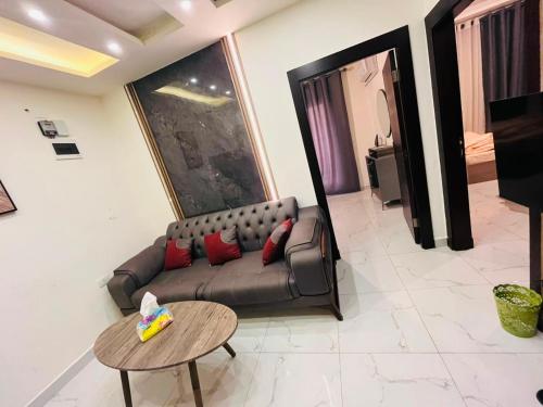 a living room with a couch and a table at شقة أنيقة-غرفتين وصالة مع بلكونة Stylish 2-Bedroom Apartment with Balcony in Amman