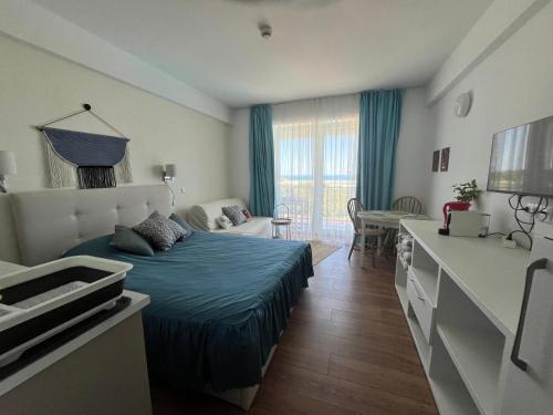 a bedroom with a bed and a living room at Studio Cris Sea View in Blaxy Residence in Douăzeci şi Trei August