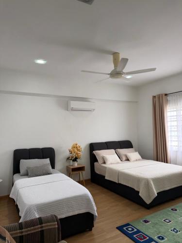 a bedroom with two beds and a ceiling fan at Singgah homestay saujana aster in Putrajaya