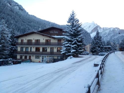 a snow covered road in front of a building at IHR Hotel Villa Emma in Canazei