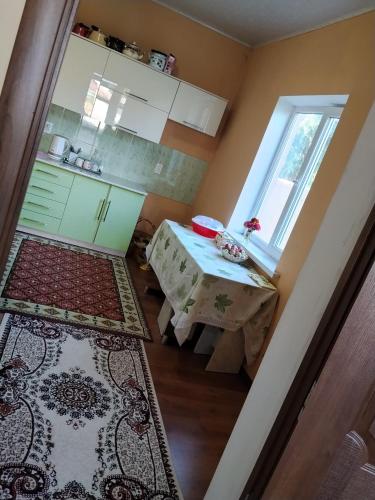 a small kitchen with a table and a window at OMKA Guest House in Toktogul