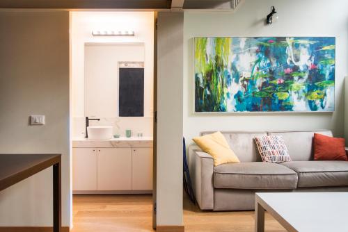 a living room with a couch and a painting on the wall at Youhosty - Lambro12 in Milan