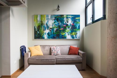 a couch in a living room with a painting on the wall at Youhosty - Lambro12 in Milan