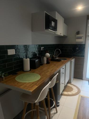 a kitchen with a wooden counter top with stools at Studio meublé in Orsay