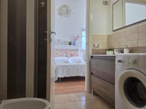 a bathroom with a sink and a washing machine at Charming studio apartment with parquet in Altamura