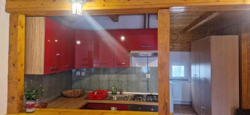 a kitchen with red cabinets and a sink at Apartman DANE in Štikada