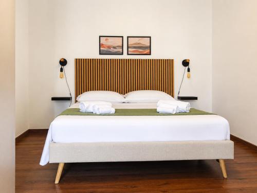 a bedroom with a large bed with two lamps at Zurria Rooms in Catania