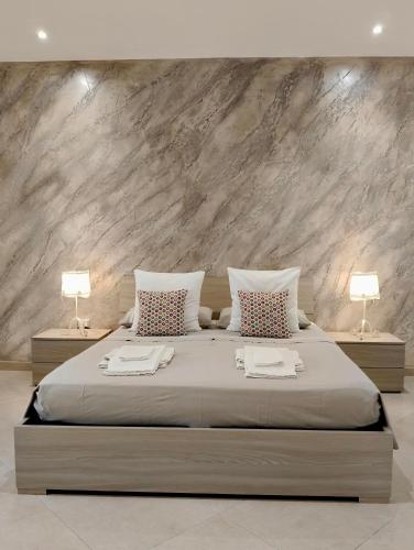 a bedroom with a large bed with two lamps at Casa Low Cost in Tuglie