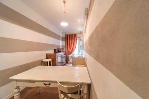 a table and chairs in a room with a wall at Palazzo Dalla Rosa Prati in Parma
