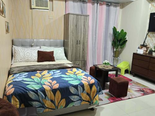 a bedroom with a bed with a colorful blanket at Manhattan Heights TowerD-Unit5 Viv's room Studio type in Manila