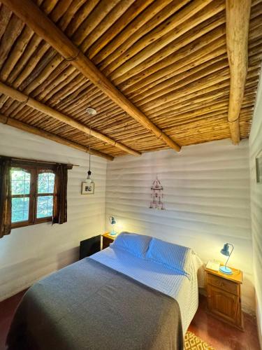 a bedroom with a bed and a wooden ceiling at El Caserío Jujuy in Volcán