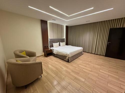 a hotel room with a bed and a chair at ارام للشقق المخدومة in Taif
