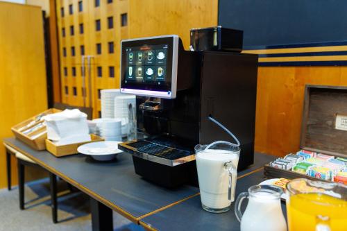 ein Tisch mit einer Kaffeemaschine und einem Getränk darauf in der Unterkunft Hotel FIT in Přerov