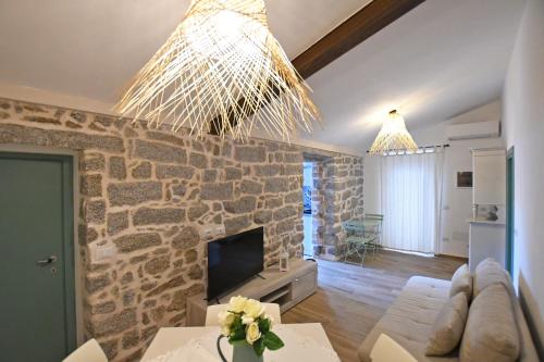 a living room with a stone wall at Stazzo Rosalba in Arzachena