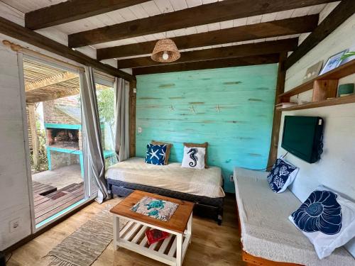 a room with two beds and a tv and a couch at Posada Agua Marina in La Paloma