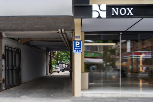 a parking sign in front of a no parking garage at NOX Hotel in Chengdu