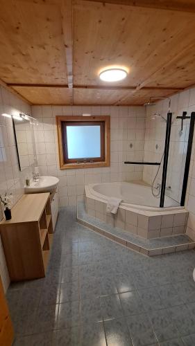 a large bathroom with a tub and a sink at Ferienhaus Berger in Virgen
