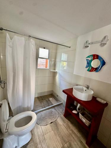 a bathroom with a toilet and a sink at Posada Agua Marina in La Paloma
