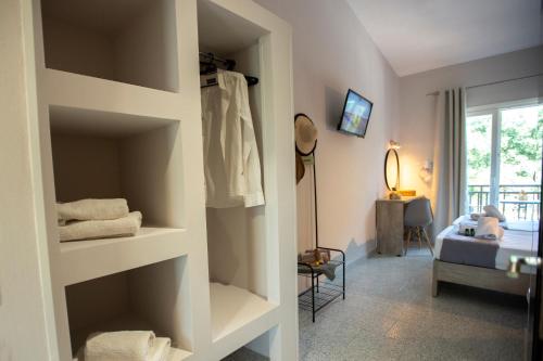 a room with white shelves and a room with a bed at Ilias Apartments in Ipsos
