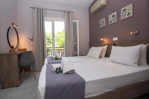 a hotel room with two beds and a mirror at Ilias Apartments in Ipsos