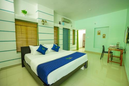 a bedroom with a bed with blue and white pillows at Rock Haven Wayanad Resort and Experiences in Kalpetta
