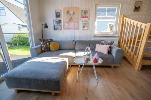 a living room with a couch and a table at Skandi Design Ferienhaus mit Hafenblick & Beach in Wandlitz