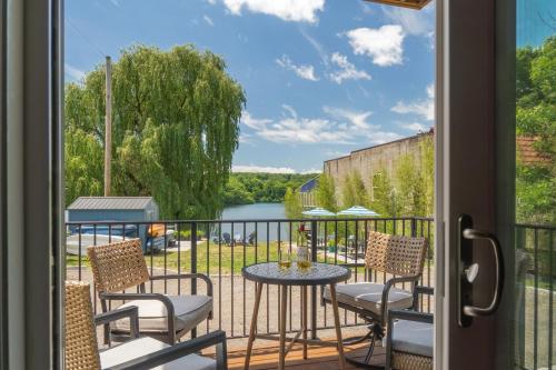 a balcony with a table and chairs and a view of a river at Saugerties Waterfront Getaway in Saugerties