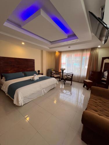 a large bedroom with a bed and a couch at Meraki Hotel in Baños