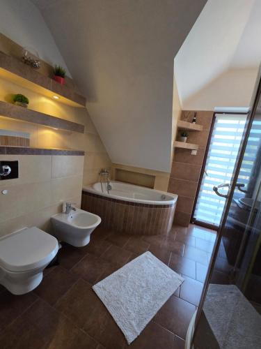 a bathroom with a tub and a toilet and a sink at Agroturystyka u Kasi in Suryty