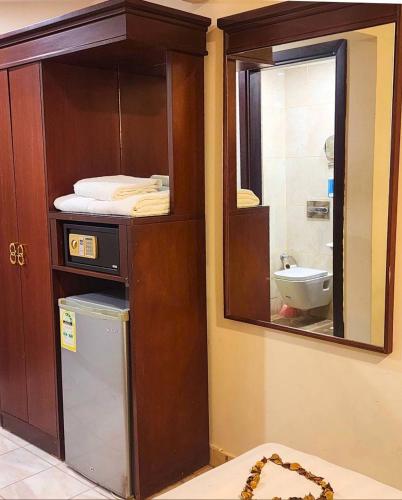 a bathroom with a mirror and a sink and a toilet at Vivian AL Shasha in Mecca