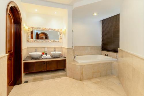 a bathroom with two sinks and a bath tub at Village du Pecheur in Baie Sainte Anne