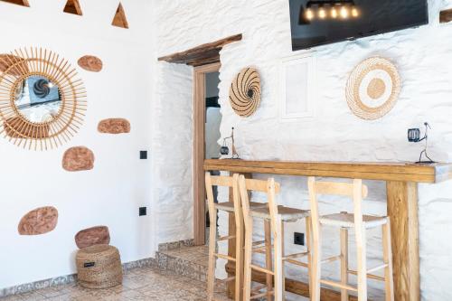 a bar with stools in a room with white walls at Aloni Houses Kythnos in Loutra