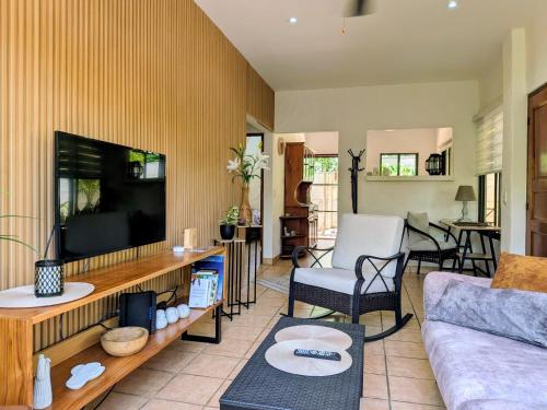 a living room with a couch and a flat screen tv at Hotel Casa Buenavista - Adults only in Sámara