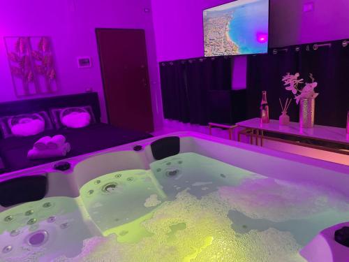 a bathroom with a large tub with purple lighting at Atena B&B APARTMENTS Platino in San Silvestro