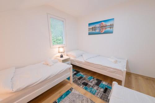 a bedroom with two beds and a window at Golden Lake House in Konjic