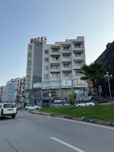 a building with a sign on top of it on a street at Grand Mongolia in Rawalpindi