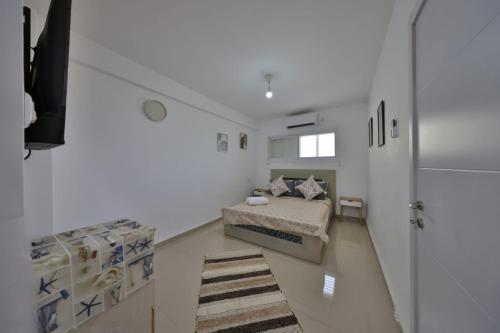 a bedroom with a bed in a white room at אירוח סמוך לים התיכון יש מקלט בבניין in Haifa
