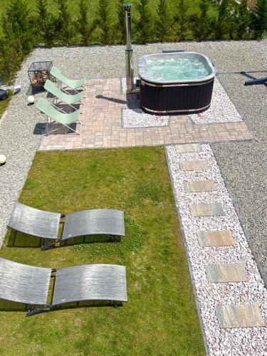 a pool with two chairs and a hot tub at Cabana Carpatin in Ocna-Mureşului