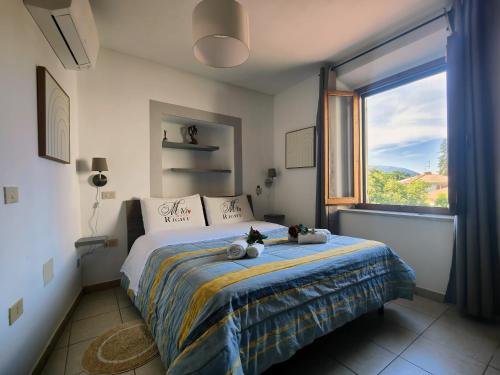 a bedroom with a bed with a large window at Casa Vacanze Le Cascate in Le Marmore
