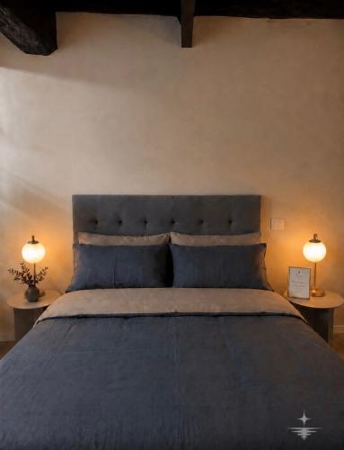 a bedroom with a large blue bed with two lamps at Vega Suite in Bracciano