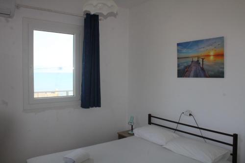 a bedroom with a bed and a window at Anastazia's Seaside Apartments in Roda