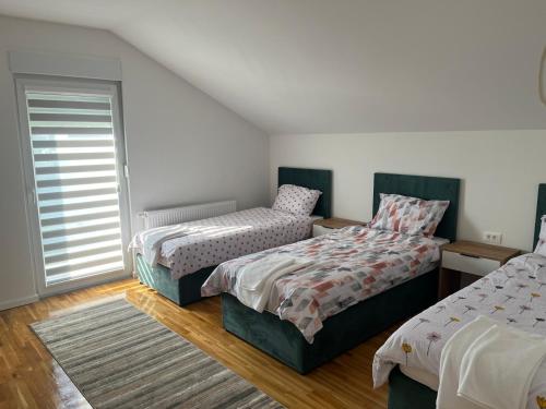 a bedroom with two beds and a window at Villa Vildana in Sarajevo