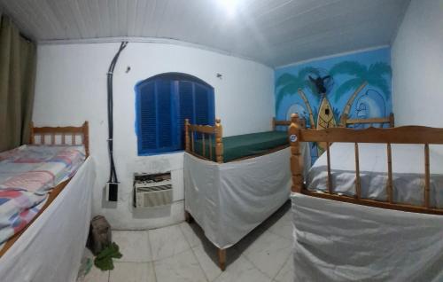 a bedroom with two bunk beds and a window at Bouganvile Hostel Ilha Grande in Abraão