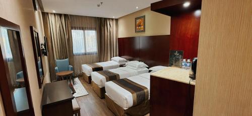 a hotel room with four beds at الارض المتميزة -1 - نبراس الهدى - Nebras ElHoda in Mecca