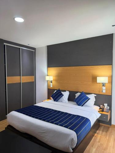 a bedroom with a large bed with blue and white pillows at Sabah Resort Nouakchott in Nouakchott