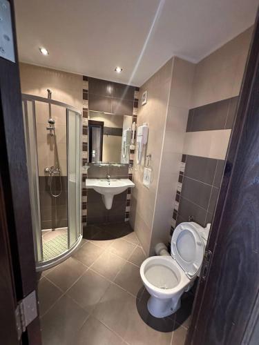 a bathroom with a toilet and a sink and a shower at Tropics Hotel by Aleksis in Sveti Vlas